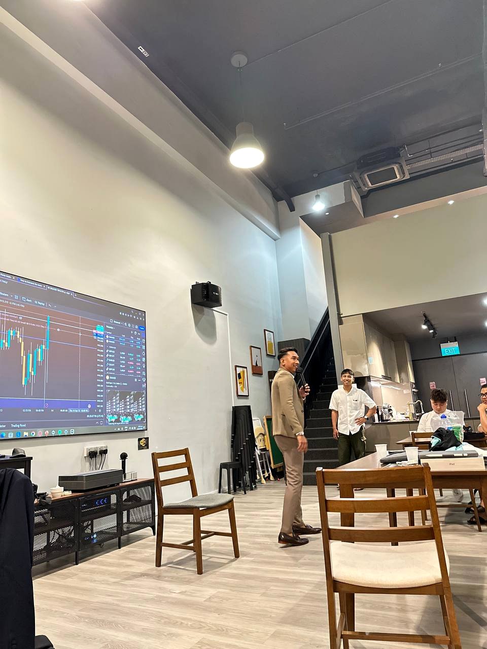 Instructor speaking during a PounderFX group mentorship class with students seated around the room.